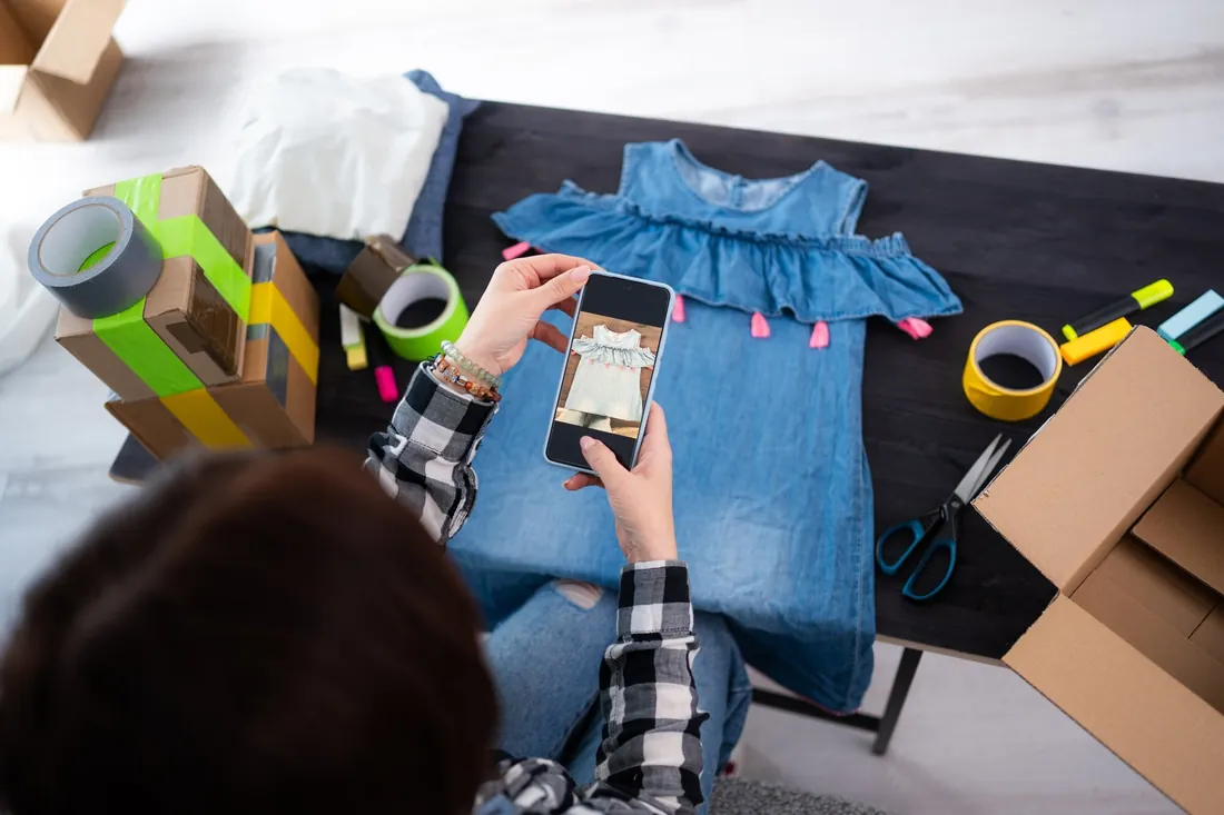 Pessoa fotografando um vestido com o celular para anunciar